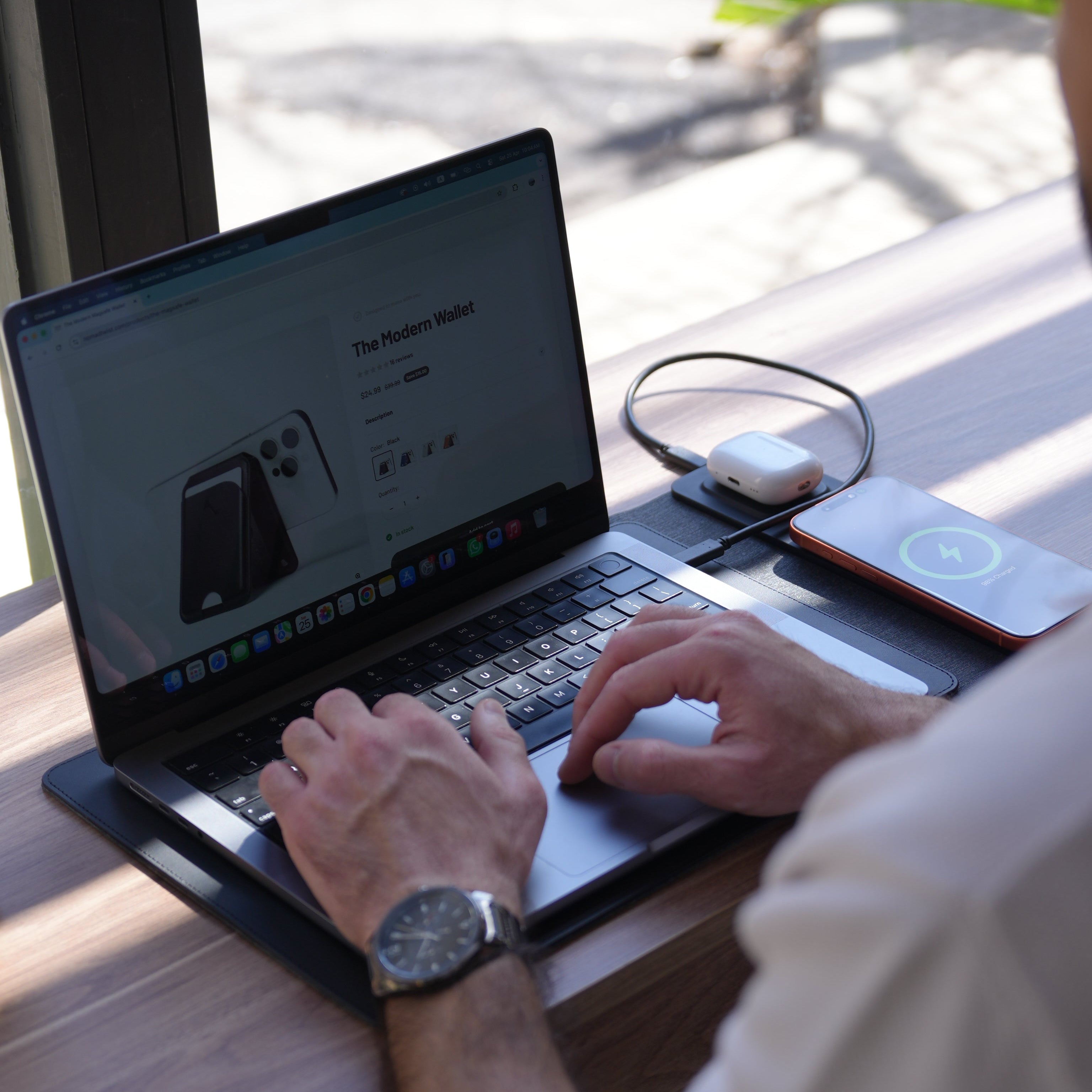 A person using a laptop, with a wireless charging sleeve.